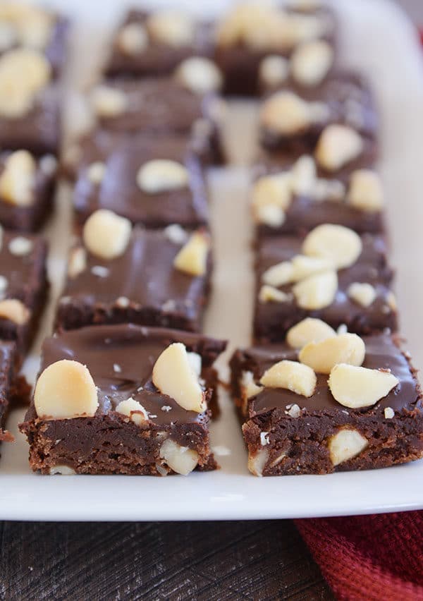 A white platter of chocolate macadamia nut brownies.