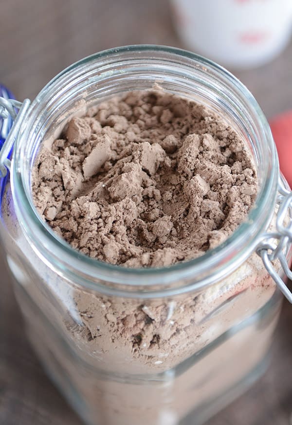 A glass jar full of powdered hot chocolate mix.