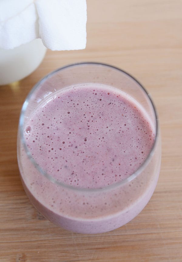 Top view of a glass with a purple berry kefir drink. 