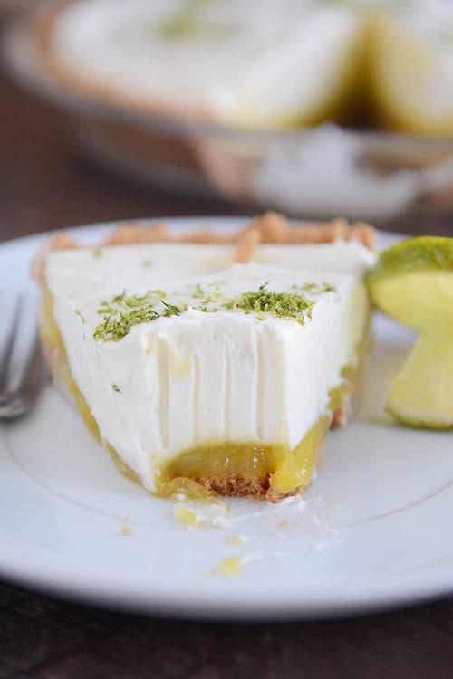 A slice of key lime cheesecake with a bite taken out.