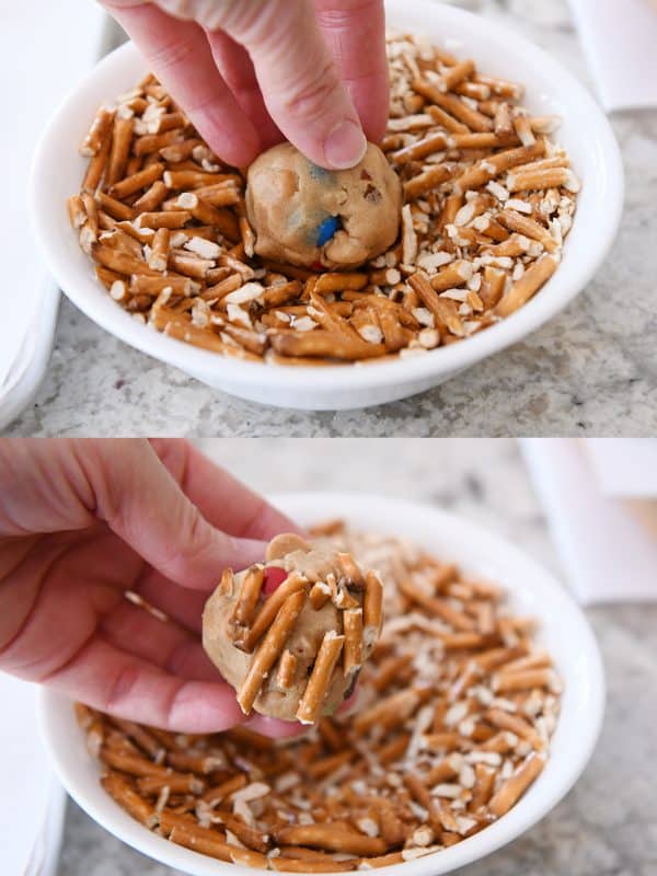 Pressing crushed pretzels into unbaked peanut butter kitchen sink cookie dough ball.