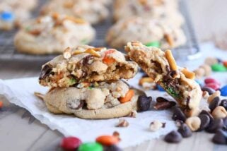 Baked peanut butter kitchen sink cookies with one broken in half.