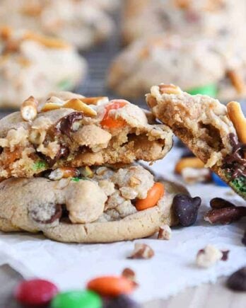 Baked peanut butter kitchen sink cookies with one broken in half.