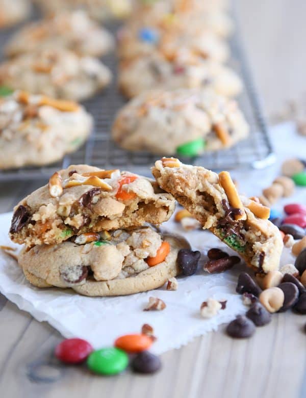 Baked peanut butter kitchen sink cookies with one broken in half.