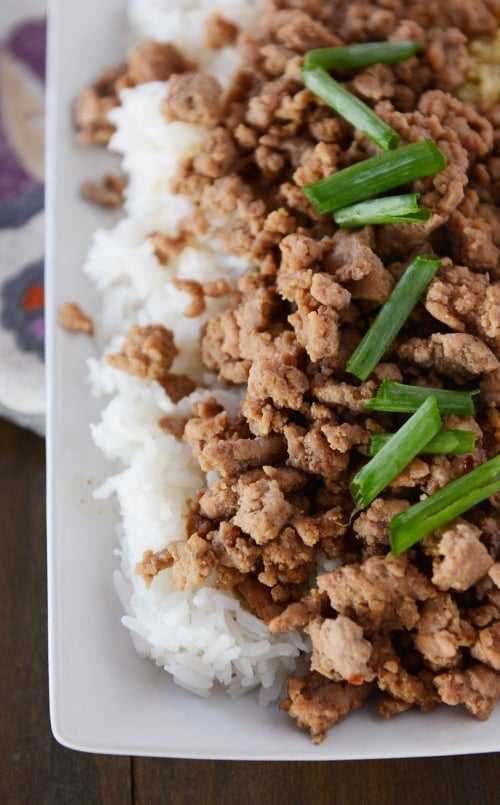 A top view of cooked white rice with Korean beef on top. 