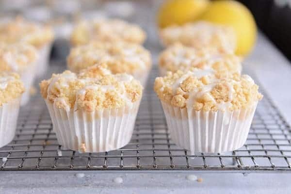 Frosting drizzled lemon crumb muffins on a cooling rack. 