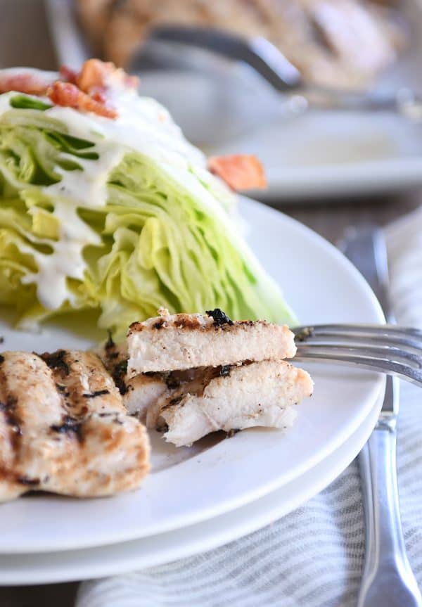 Lemon garlic grilled chicken cut into pieces on white plate.