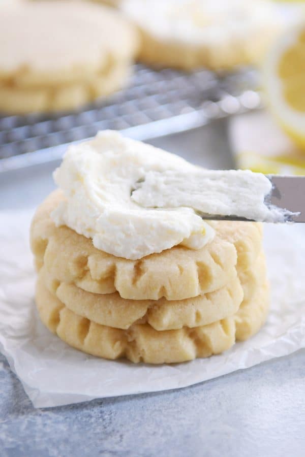 Stack of three lemon swig sugar cookies with pile of frosting on top.