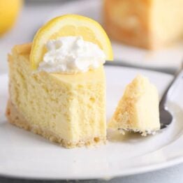 Slice of lemon white chocolate cheesecake on white plate.