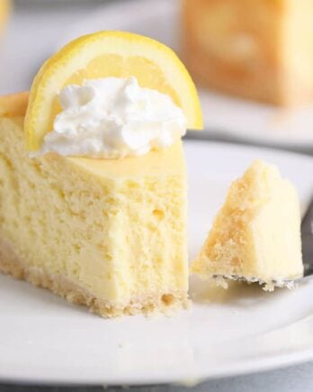 Slice of lemon white chocolate cheesecake on white plate.