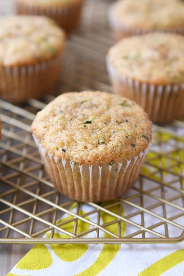 Lemon poppy seed zucchini muffins on wire cooling rack.