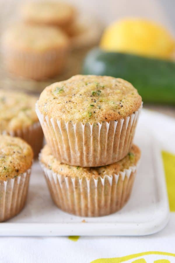 Two lemon zucchini poppy seed muffins stacked on each other.