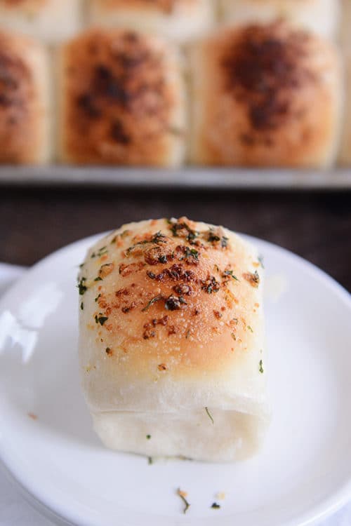 Asiago and herb dinner roll on a white plate.