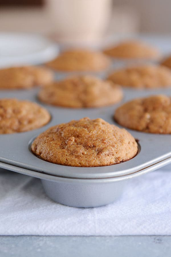 A muffin tin full of cooked bran muffins. 