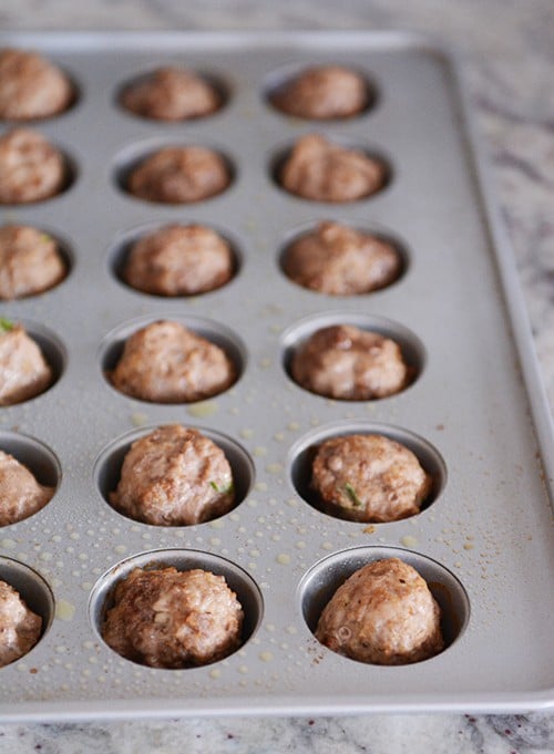 Cooked meatballs in a mini muffin tin. 