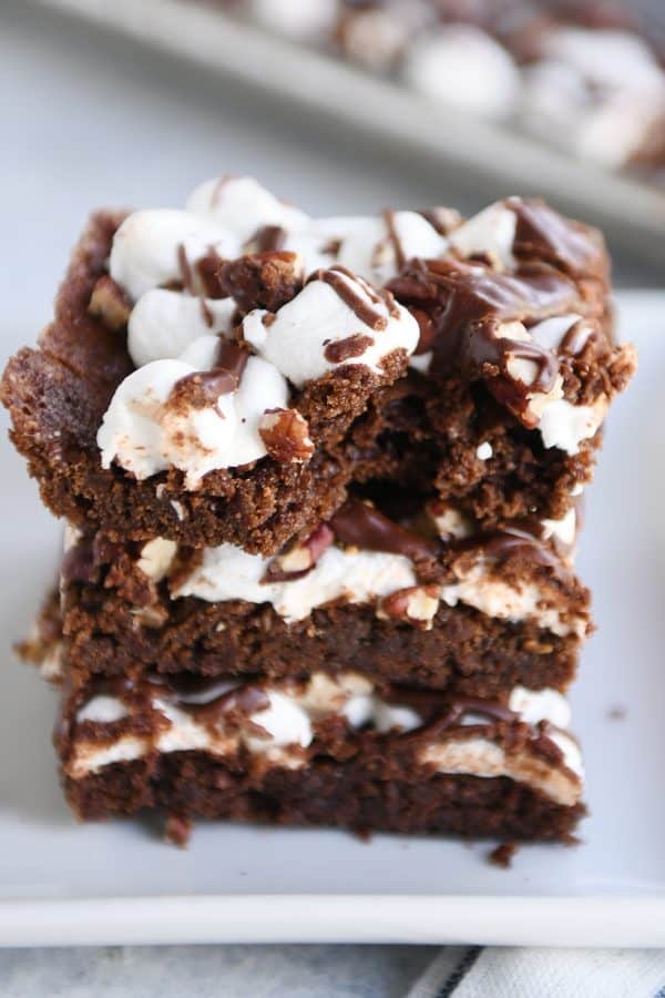 Three Mississippi Mud Bars stacked on top of each other on a white tray with a bite taken out of the top bar.