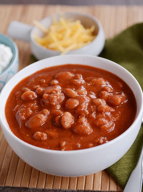 A white bowl of beef and bean red chili. 