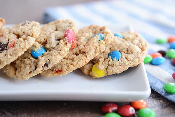 A tray of M&M oat cookies with additional M&M's sprinkled around the platter.