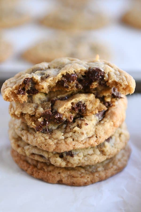 Stack of soft and chewy oatmeal chocolate chip coconut cookies with the top one broken in half.