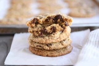 Stack of soft and chewy oatmeal chocolate chip coconut cookies with the top one broken in half.