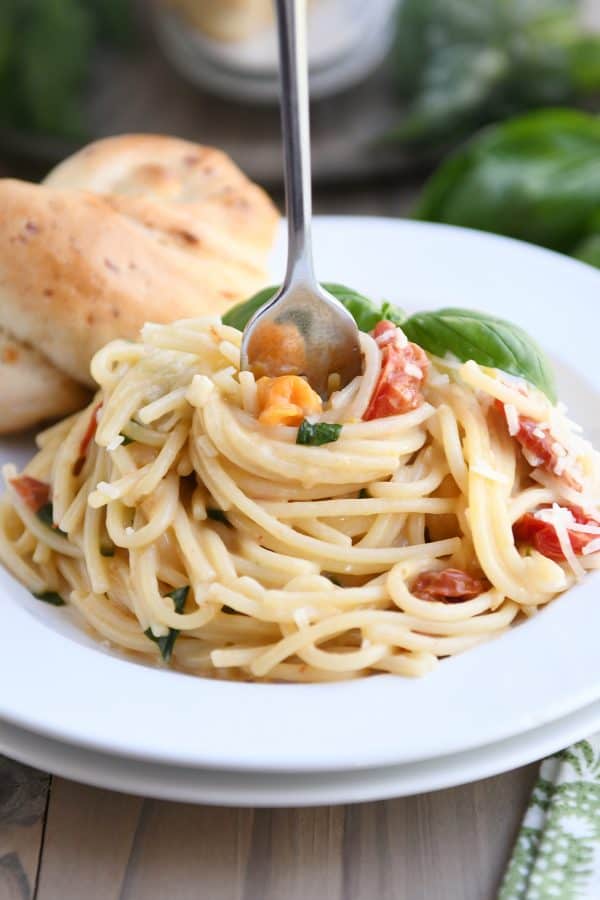One pot creamy tomato basil pasta on white plate.