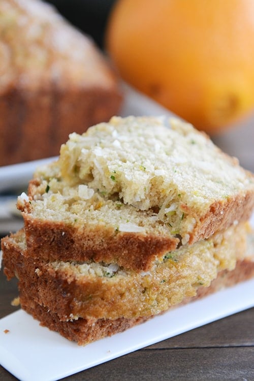 Thick slices of orange zucchini bread stacked on top of each other. 