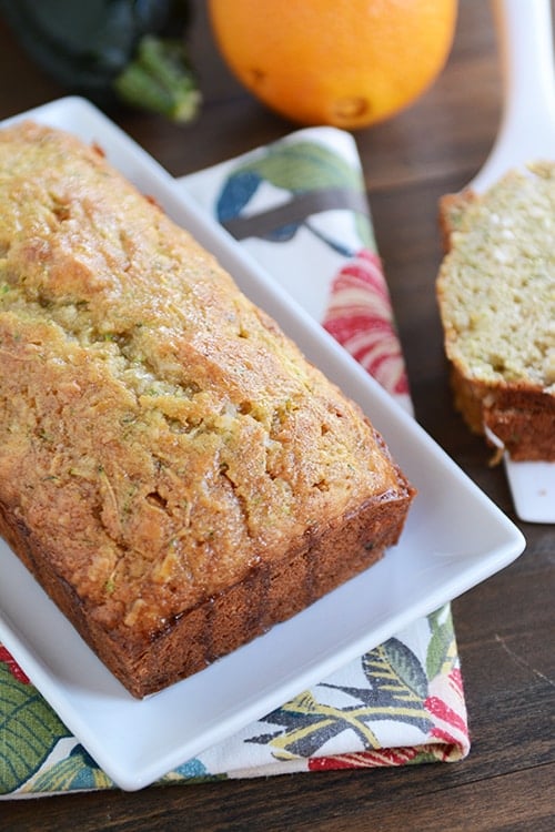 A loaf of zucchini bread on a white platter. 