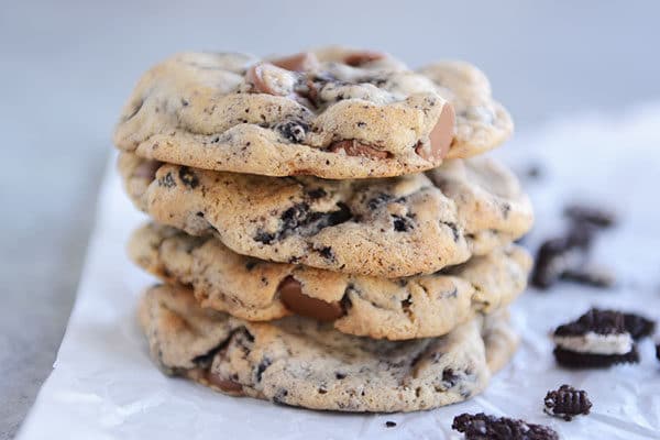 Four chocolate chip Oreo cookies stacked on top of each other with chunks of Oreo beside them.
