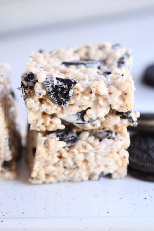 Two oreo rice krispie treats stacked on each other on white tray.