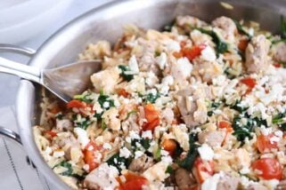 Stainless pan filled with Mediterranean orzo skillet with pork.