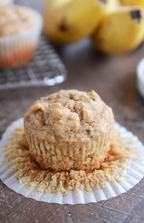 A peanut butter banana muffin sitting on a white muffin liner.
