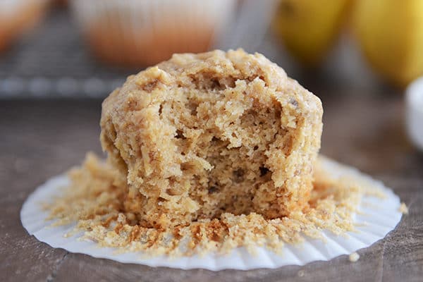 A peanut butter banana muffin on a white liner with a bite taken out.