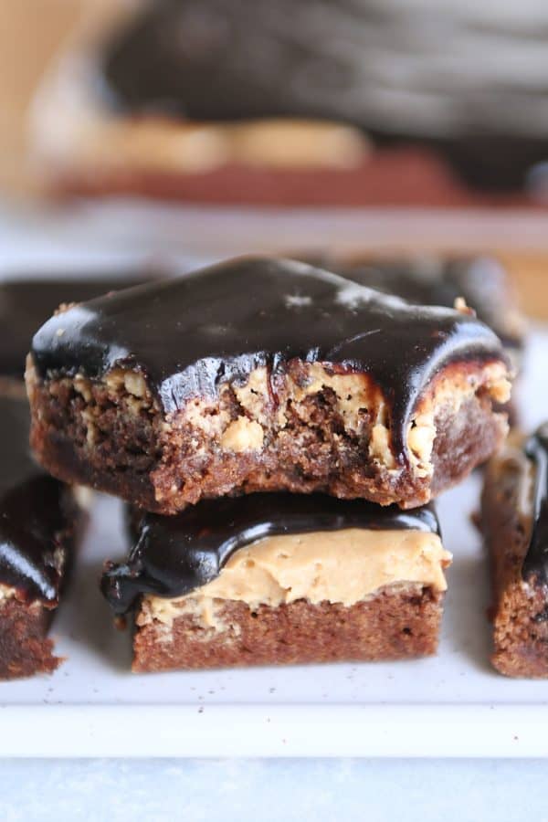 Stack of peanut butter marshmallow fudge brownies with bite taken out.