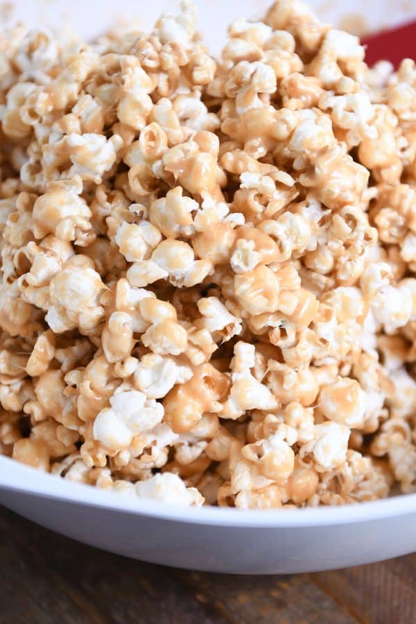 White bowl filled with soft and chewy peanut butter caramel popcorn.