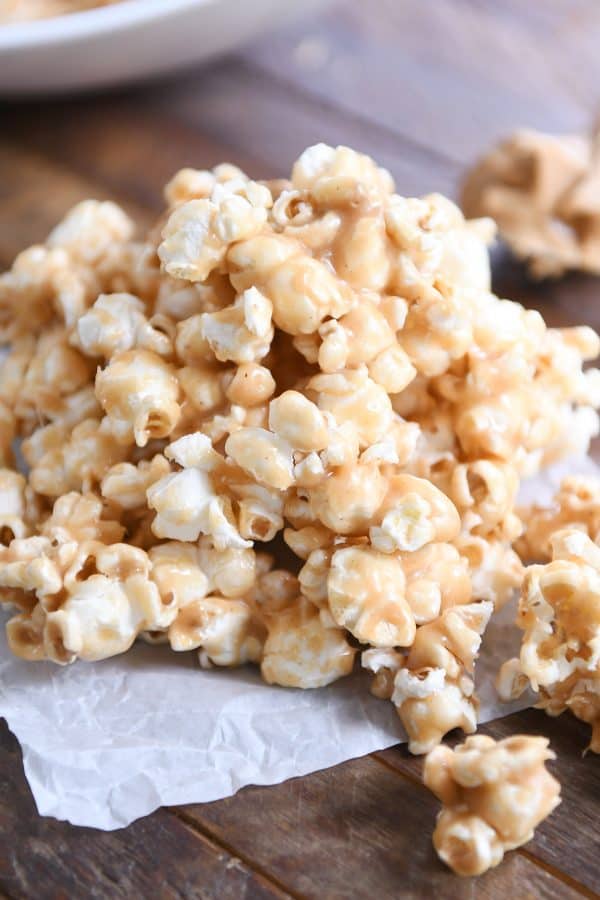 Pile of soft and chewy peanut butter caramel popcorn on was paper.