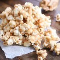 Pile of soft and chewy peanut butter caramel popcorn on was paper.