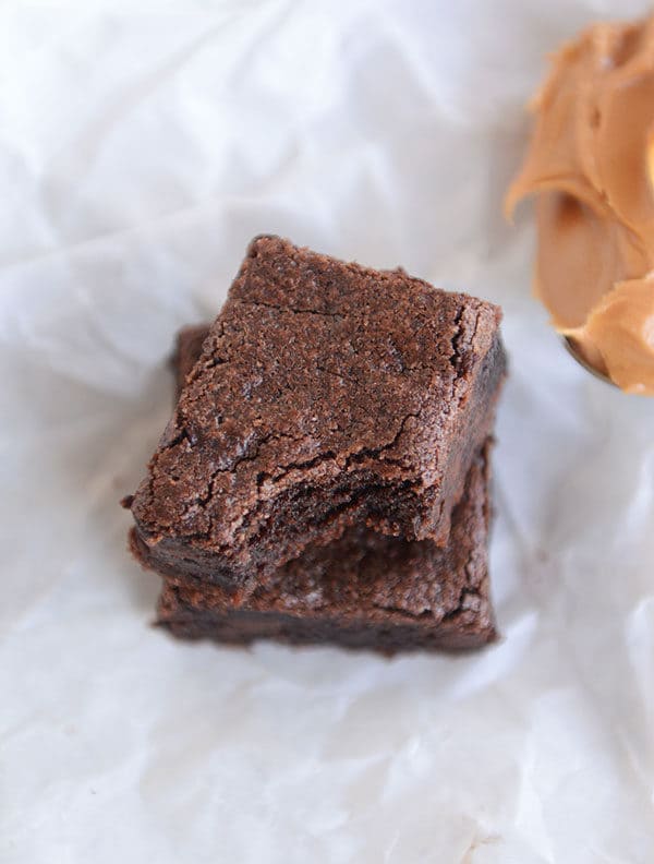 Top view of a brownie with a bite taken out stacked on top of another brownie.