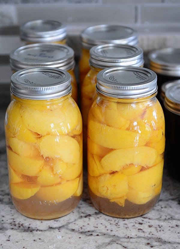 Canned peaches on a granite countertop. 