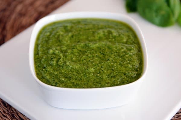 A white square dish full of basil pesto. 