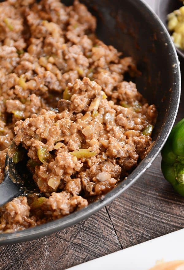 A skillet full of cooked beef sloppy joe mixture. 