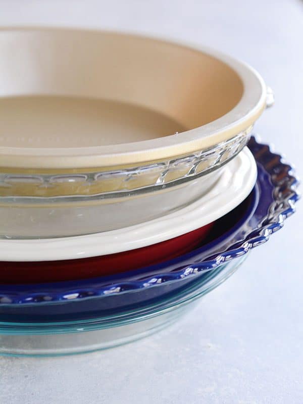 A stack of various colors and sizes of pie dishes.