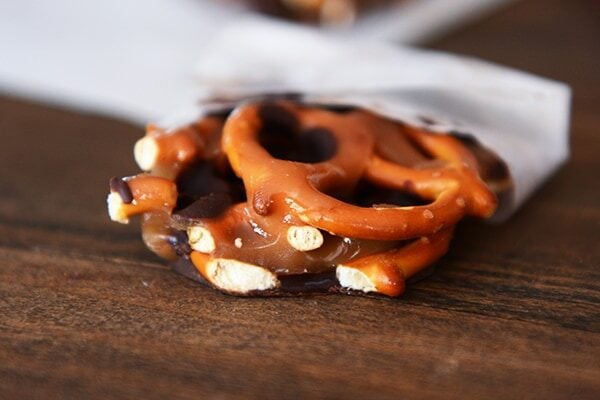 A chunk of chocolate caramel pretzel bark tucked into a piece of parchment.