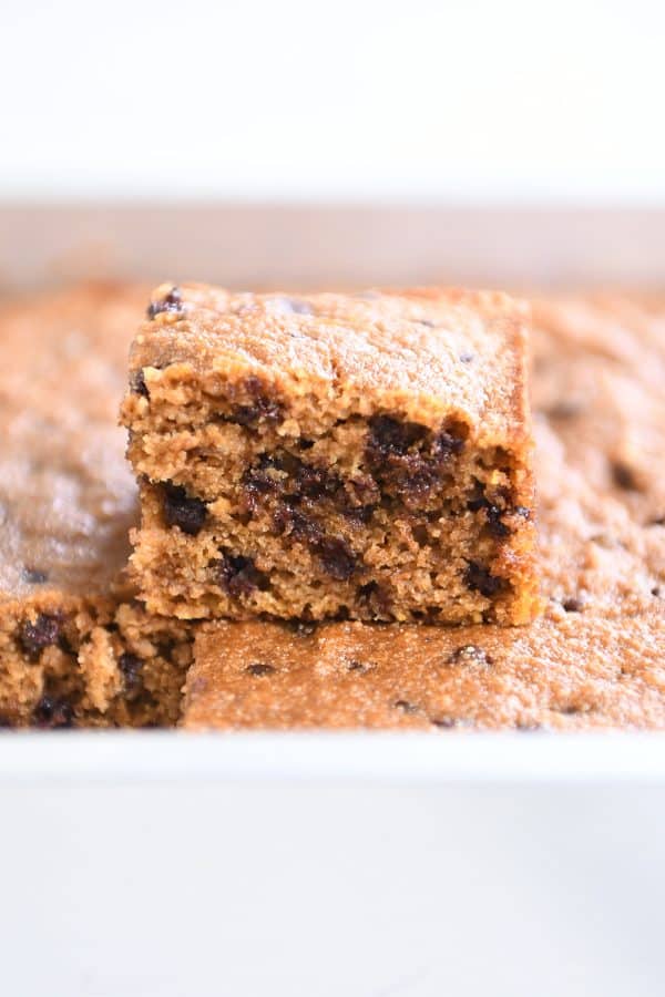 Square piece of pumpkin chocolate chip snack cake on top of baked bars.