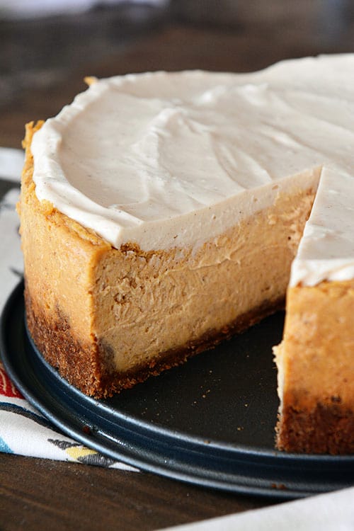 A thick pumpkin white chocolate cheesecake with a slice cut out.