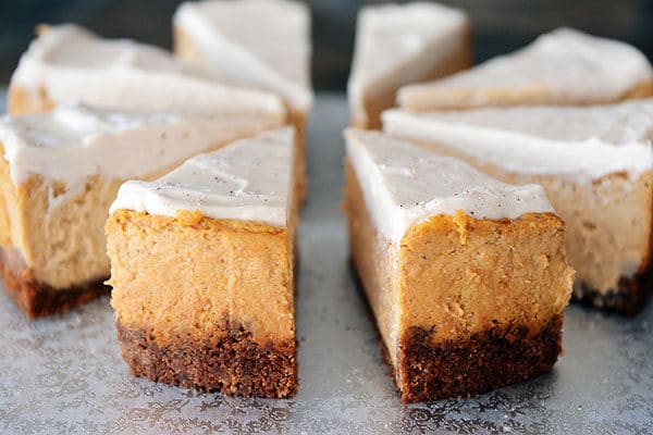 Eight slices of pumpkin white chocolate mousse cheesecake slightly spread out from each other.