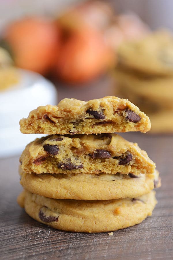 A stack of pumpkin chocolate chip cookies with the top cookie split in half.