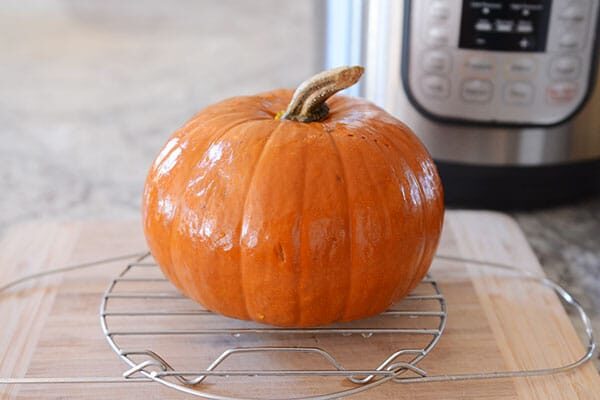A small cooked pumpkin on a cooling rack.