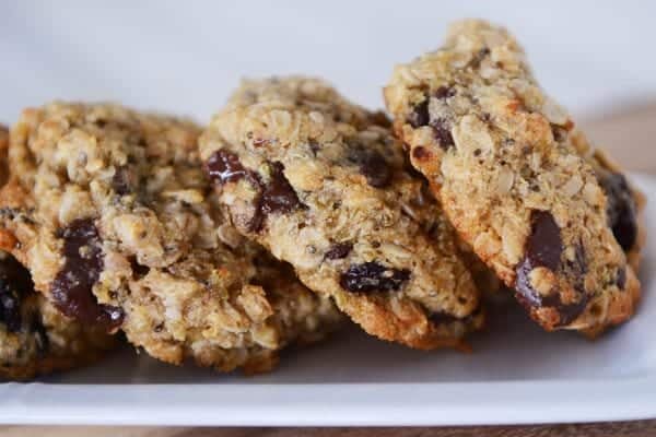 Three chocolate chip oat cookies leaned up next to each other.