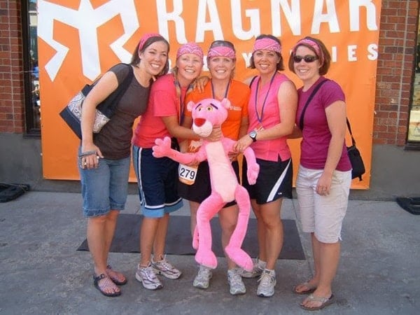 A group of ladies holding a big stuffed Pink Panther.