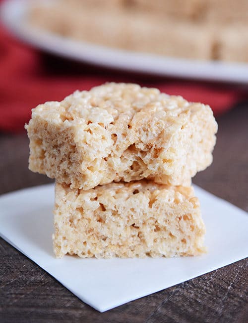 Two rice krispie treats stacked on top of each other. The top treat has a bite taken out.